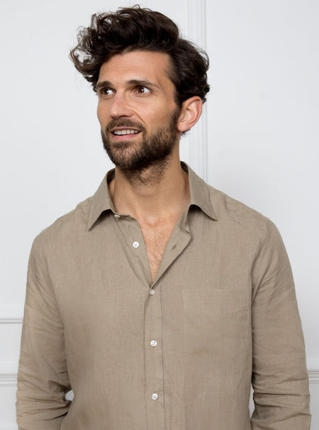 Man wearing a tan long sleeved shirt with pocket detail made with 100% linen in a Thomas Mason fabric.